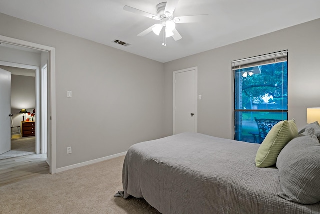 carpeted bedroom with visible vents, baseboards, and ceiling fan