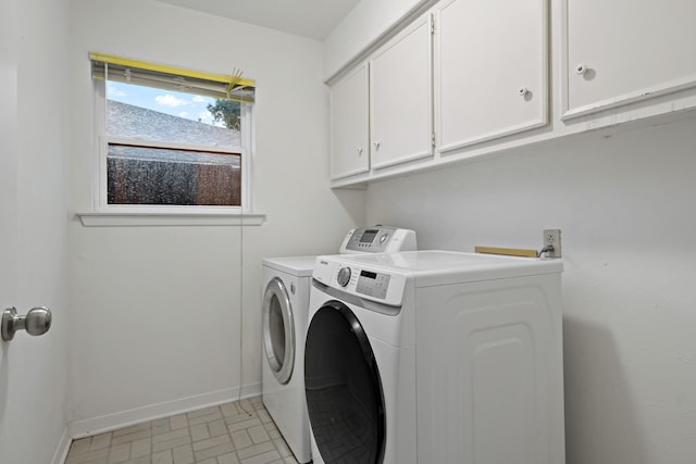 laundry area with cabinet space, baseboards, and washing machine and clothes dryer