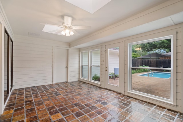 unfurnished sunroom with visible vents and a skylight