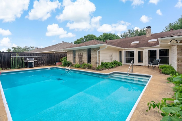 view of pool with fence, a fenced in pool, grilling area, and a patio