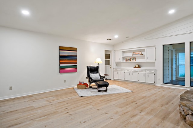 living area with light wood-style floors, recessed lighting, and vaulted ceiling