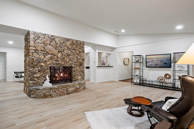 living room featuring baseboards, a stone fireplace, recessed lighting, and wood finished floors