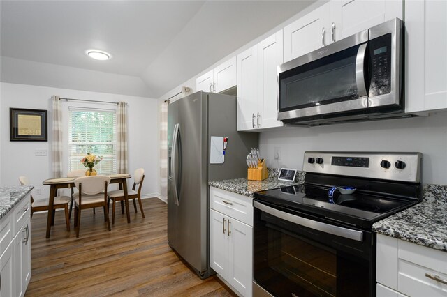 kitchen featuring light stone counters, white cabinetry, wood finished floors, and stainless steel appliances