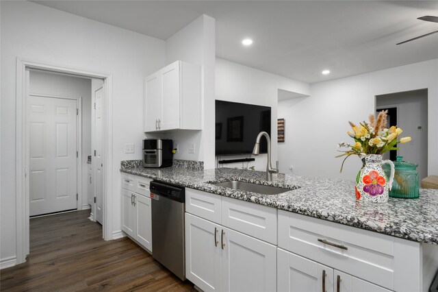 kitchen featuring light stone counters, dark wood-style floors, a sink, and dishwasher