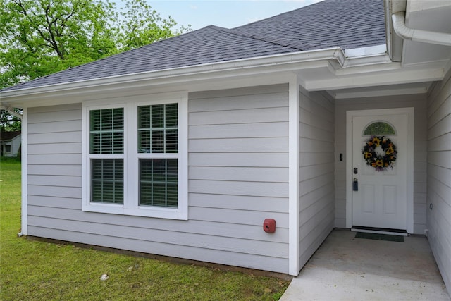 doorway to property featuring roof with shingles