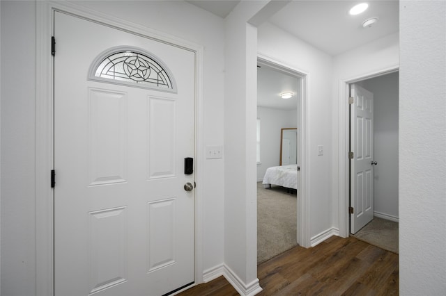 entrance foyer with dark wood-type flooring and baseboards