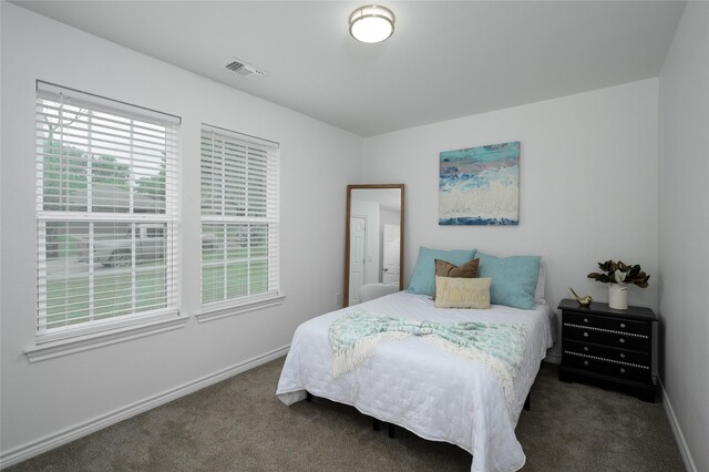 carpeted bedroom featuring baseboards and visible vents