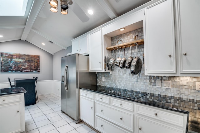 kitchen featuring stainless steel fridge, dark countertops, light tile patterned floors, and backsplash