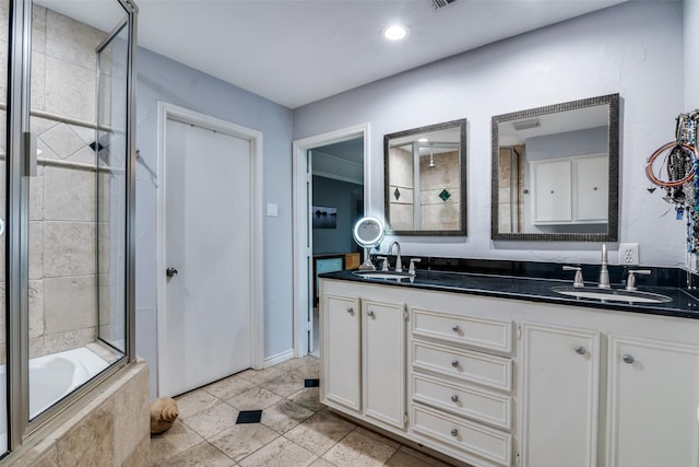 bathroom with a sink, tile patterned floors, tiled shower / bath combo, and double vanity