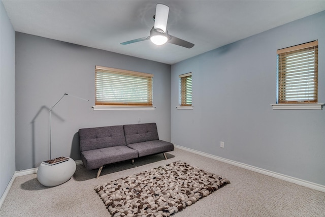 living area with carpet flooring, ceiling fan, and baseboards