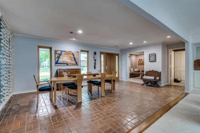 dining space featuring visible vents, ornamental molding, baseboards, recessed lighting, and brick floor