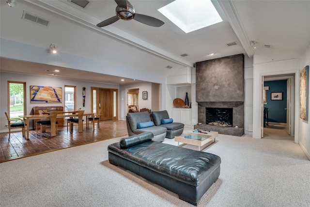 living area featuring light colored carpet, a fireplace, a ceiling fan, baseboards, and visible vents