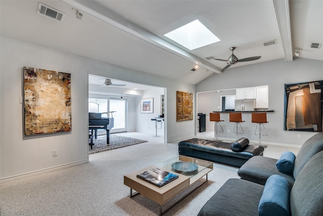 living room featuring visible vents, lofted ceiling with skylight, ceiling fan, and carpet flooring