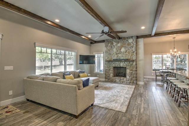 living room with ceiling fan, a chandelier, beamed ceiling, baseboards, and healthy amount of natural light
