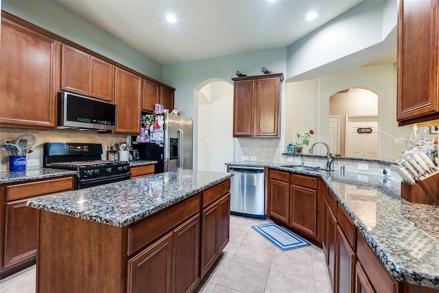 9204 Lockhart Dr, Arlington, TX 76002 - kitchen with stainless steel appliances, a sink, tasteful backsplash, arched walkways, and recessed lighting