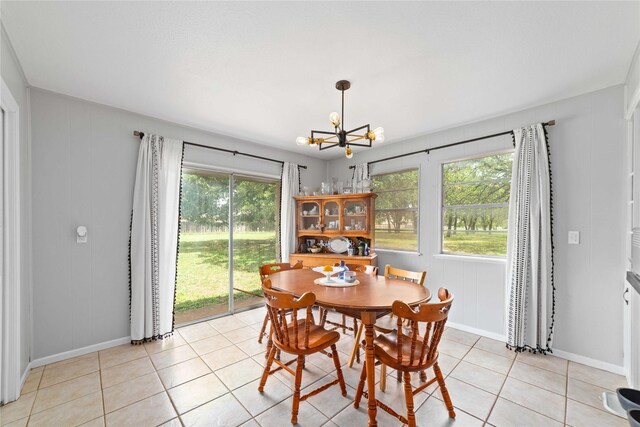 dining room with baseboards, a notable chandelier, plenty of natural light, and light tile patterned floors