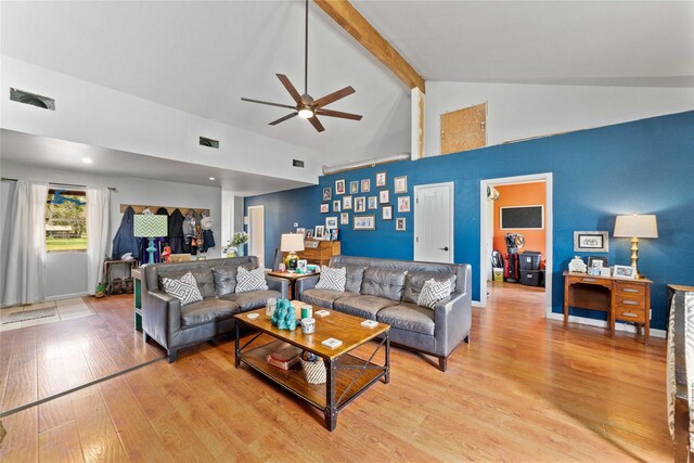 living room featuring beam ceiling, light wood finished floors, high vaulted ceiling, a ceiling fan, and visible vents
