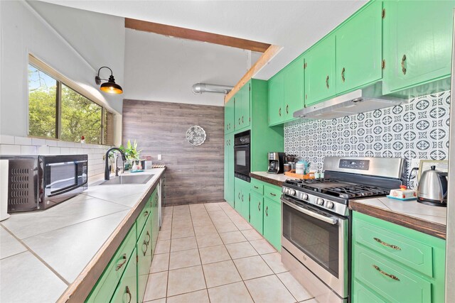 kitchen with light countertops, under cabinet range hood, tasteful backsplash, a sink, and black appliances