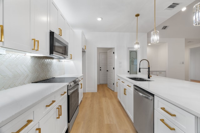 kitchen featuring a sink, appliances with stainless steel finishes, light countertops, and visible vents