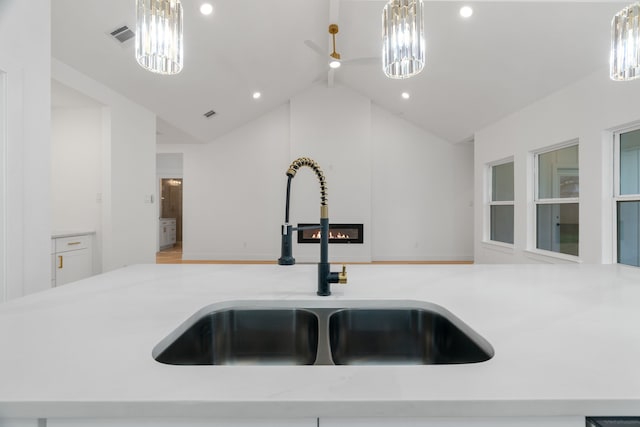 kitchen featuring visible vents, open floor plan, a chandelier, a sink, and decorative light fixtures