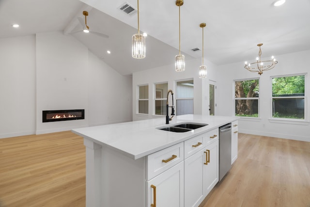 kitchen with a sink, baseboards, light wood-type flooring, stainless steel dishwasher, and visible vents
