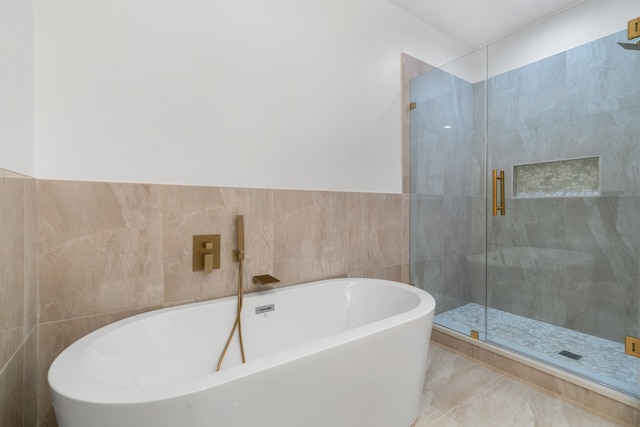bathroom featuring a freestanding bath, tile walls, and a stall shower