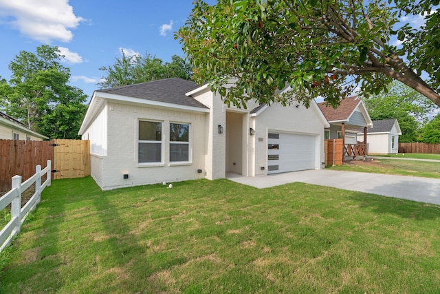 view of front facade with a front lawn, fence, brick siding, a shingled roof, and concrete driveway