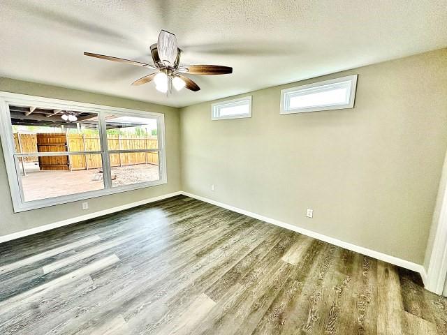 empty room featuring baseboards, ceiling fan, and wood finished floors