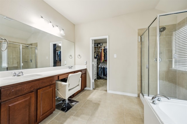bathroom with a walk in closet, a sink, tile patterned flooring, double vanity, and a shower stall
