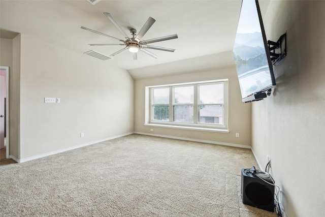 carpeted spare room featuring vaulted ceiling, baseboards, a ceiling fan, and visible vents