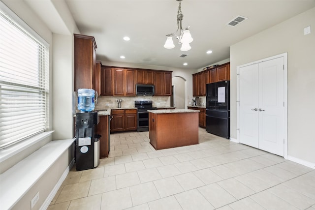 kitchen featuring backsplash, a kitchen island, visible vents, black appliances, and a notable chandelier