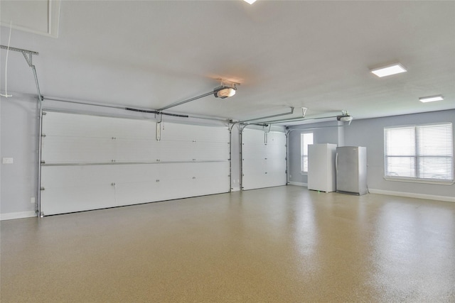 garage with baseboards, freestanding refrigerator, and a garage door opener