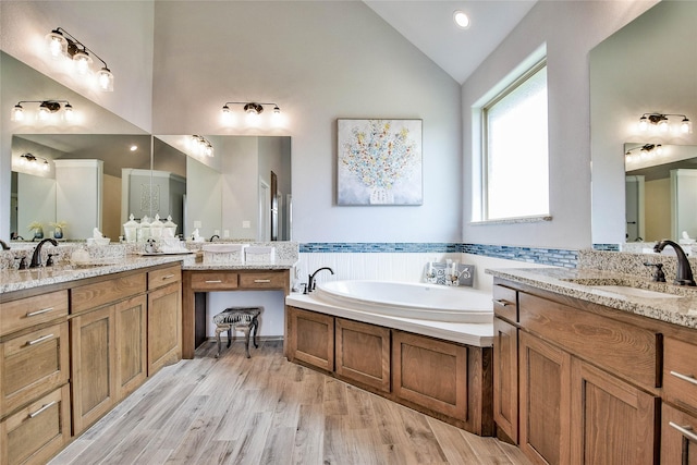 full bathroom with a sink, wood finished floors, and two vanities