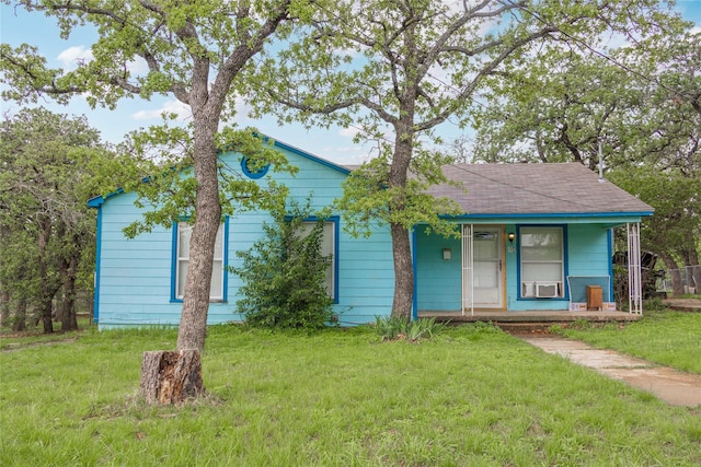 view of front facade with a porch, roof with shingles, and a front lawn