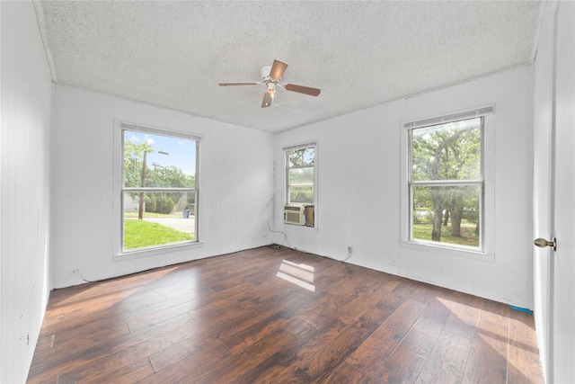 empty room with ceiling fan, cooling unit, hardwood / wood-style flooring, and a textured ceiling