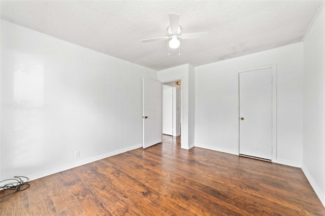 spare room featuring a ceiling fan, baseboards, wood finished floors, and a textured ceiling