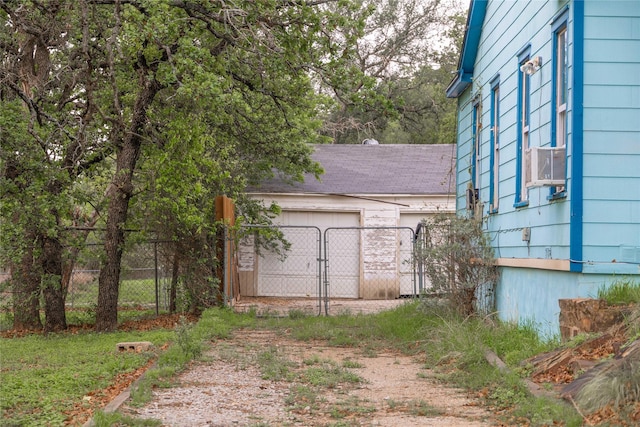 view of yard featuring fence, cooling unit, a gate, an attached garage, and driveway