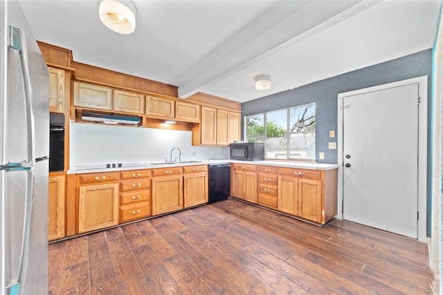 kitchen featuring beam ceiling, light countertops, black appliances, under cabinet range hood, and dark wood-type flooring