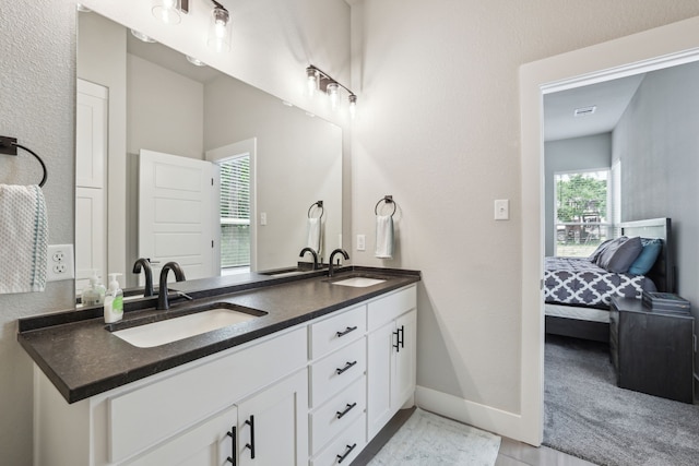 811 County Road 3451, Paradise, TX 76073 - full bath with double vanity, baseboards, visible vents, and a sink