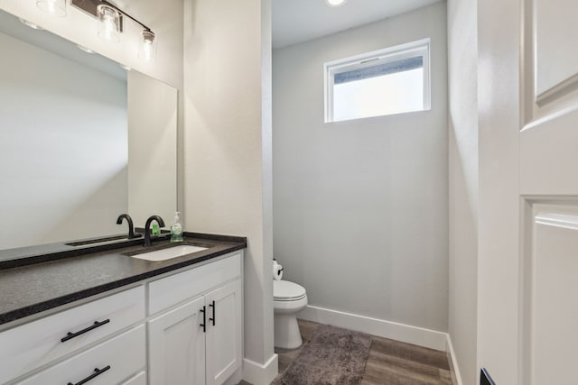 811 County Road 3451, Paradise, TX 76073 - bathroom with toilet, baseboards, wood finished floors, and vanity
