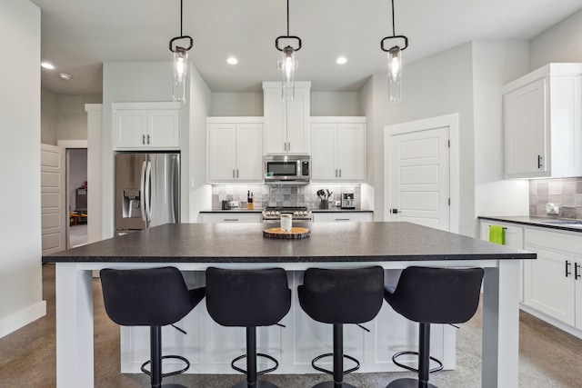 811 County Road 3451, Paradise, TX 76073 - kitchen featuring dark countertops, appliances with stainless steel finishes, tasteful backsplash, and a breakfast bar area