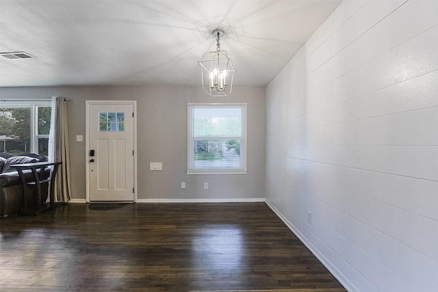 foyer featuring visible vents, baseboards, wood finished floors, and an inviting chandelier