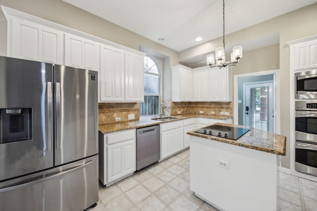 kitchen featuring white cabinets, a notable chandelier, appliances with stainless steel finishes, a sink, and backsplash