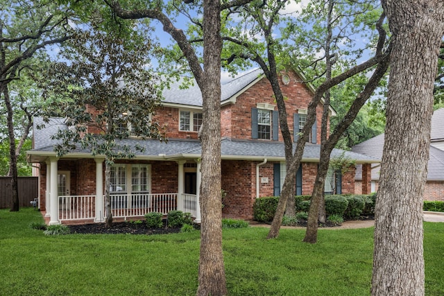 traditional home featuring roof with shingles and a front lawn