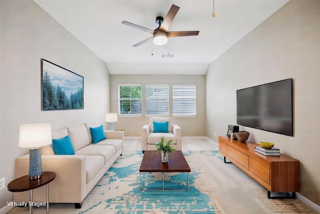 living room with baseboards, a ceiling fan, lofted ceiling, and light carpet