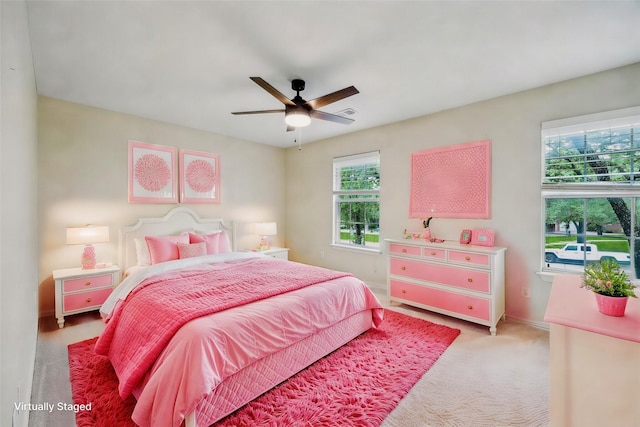 bedroom featuring baseboards, light colored carpet, and ceiling fan