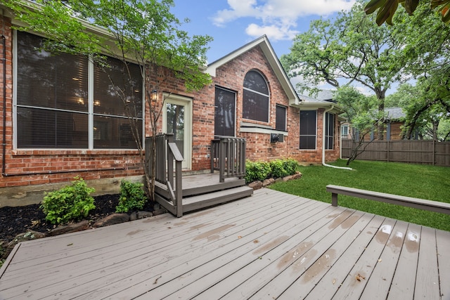wooden terrace with a lawn and fence