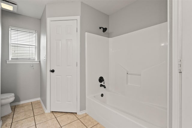 full bath with tile patterned flooring, baseboards, shower / tub combination, and toilet