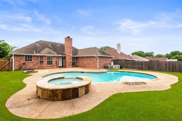 view of swimming pool featuring a pool with connected hot tub, a fenced backyard, central AC unit, a patio, and a yard