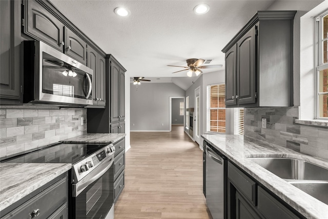 kitchen with ceiling fan, light wood-style flooring, stainless steel appliances, recessed lighting, and tasteful backsplash